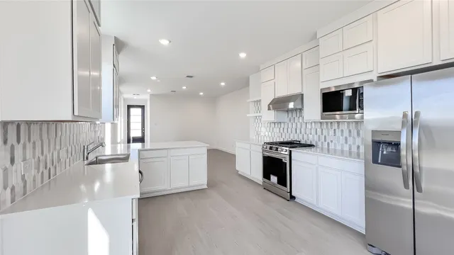 a kitchen with a sink stainless steel appliances and cabinets