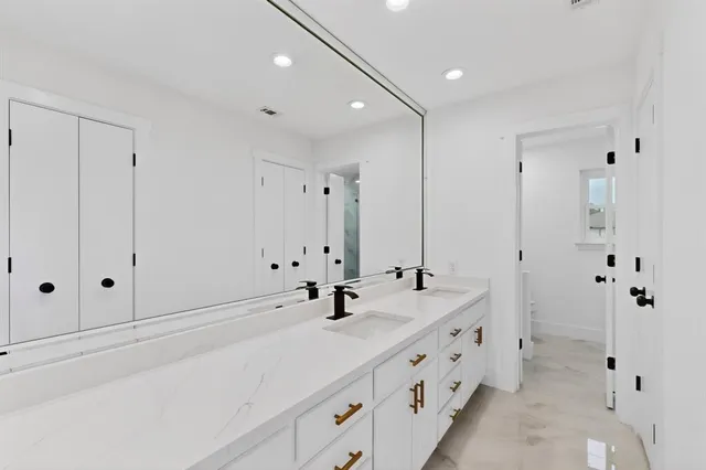 a bathroom with double vanity sink and mirror