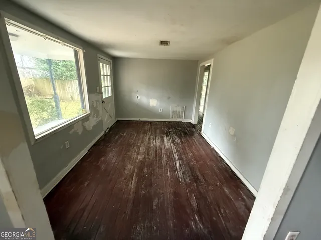 a view of wooden floor in an empty room with a window