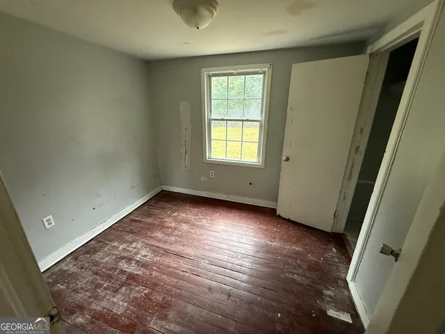 an empty room with wooden floor and window