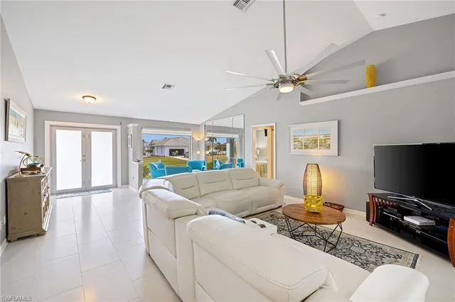 a living room with furniture a flat screen tv and a ceiling fan