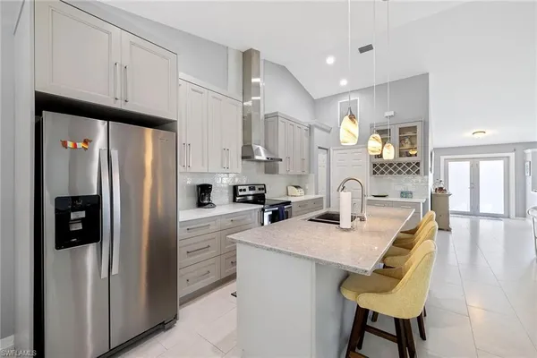 a kitchen with refrigerator a table and chairs