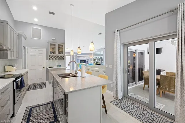 a kitchen that has a sink a table and chairs in it