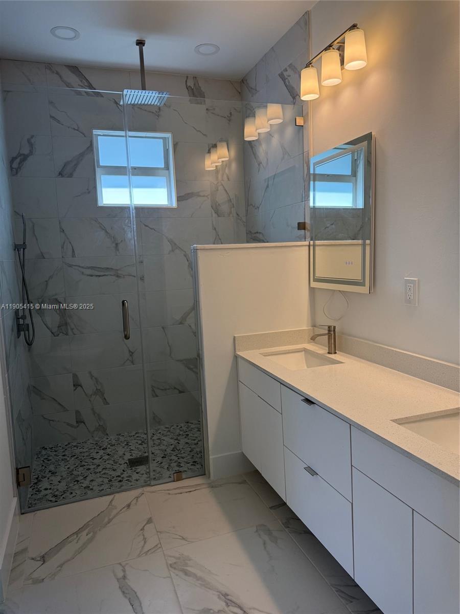 617 Valley Avenue Lehigh Acres, FL 33974 - Photo 40 of 46 a bathroom with a granite countertop sink a shower and a mirror