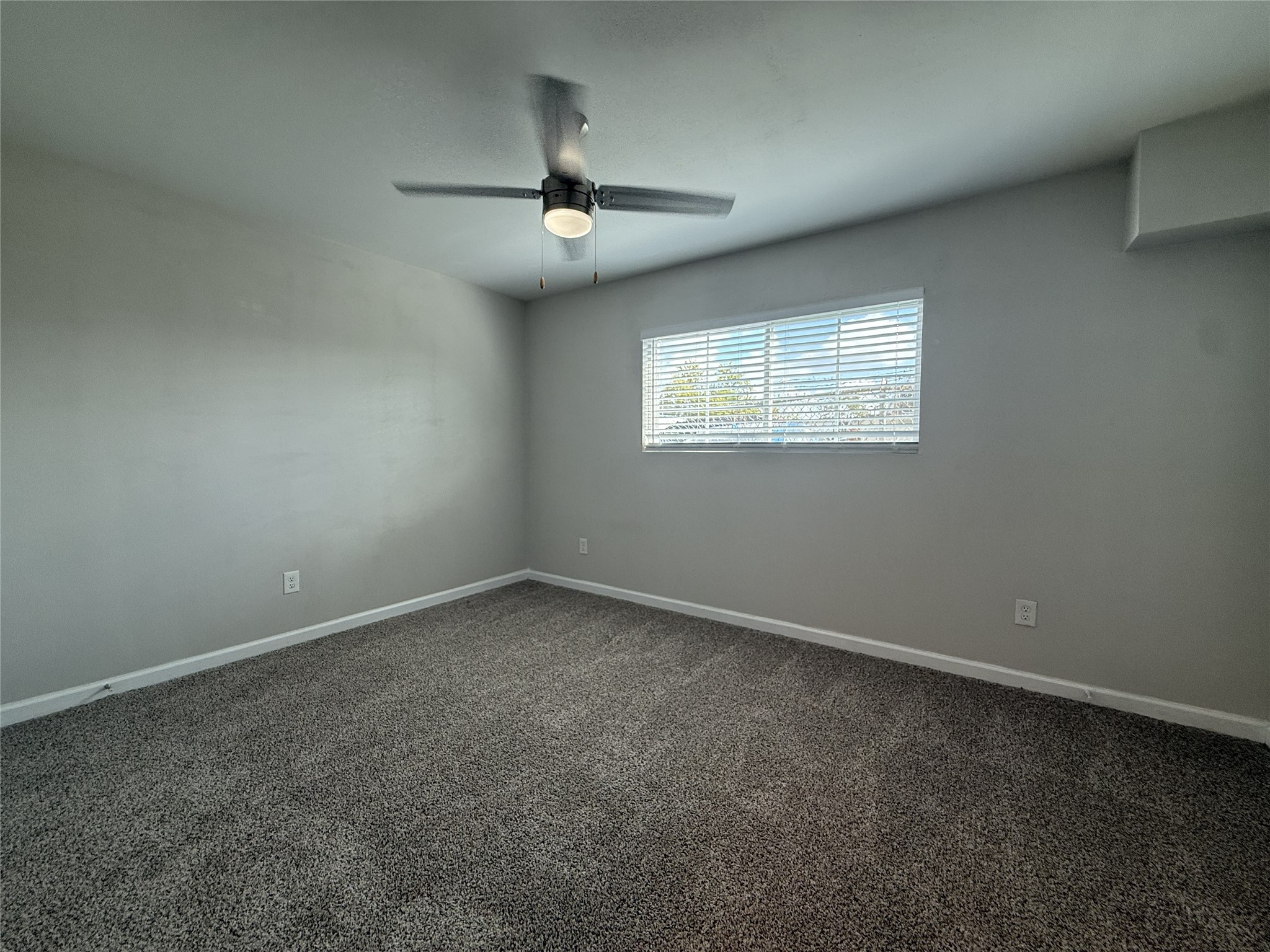 1824 Thonig Road, Unit 10 Houston, TX 77055 - Photo 9 of 17 an empty room with a chandelier fan and windows