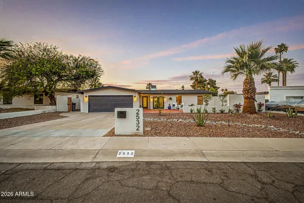 a view of a house with a yard and a garage