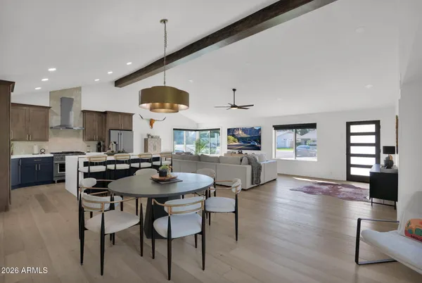 a kitchen with stainless steel appliances kitchen island granite countertop a table chairs and a refrigerator