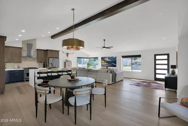 a kitchen with stainless steel appliances kitchen island granite countertop a table chairs and a refrigerator