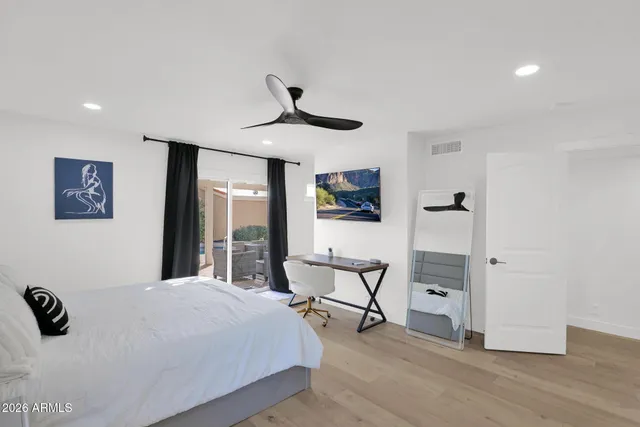 a bedroom with a bed a chair and painting on the wall