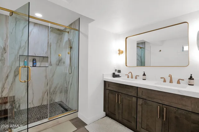 a bathroom with a double vanity sink mirror and shower