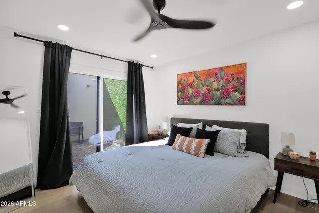 a bedroom with a large bed and a painting on the wall