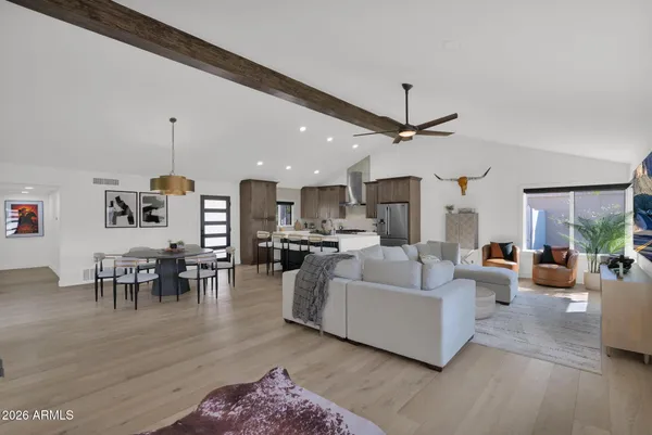 a living room with furniture a table and kitchen view