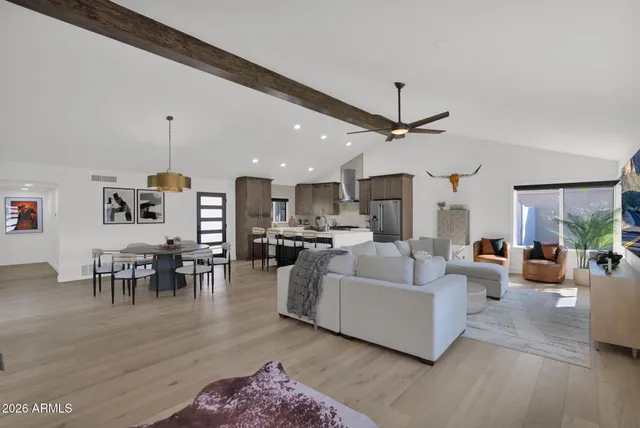 a living room with furniture a table and kitchen view