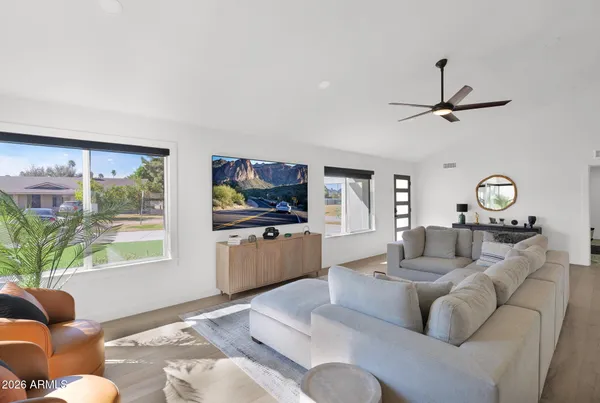 a living room with furniture a window and a flat screen tv