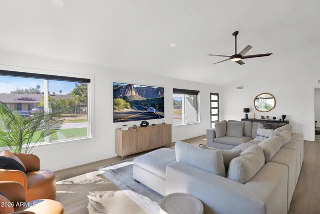 a living room with furniture a window and a flat screen tv