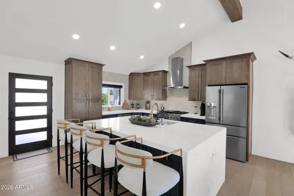 a kitchen with a dining table chairs refrigerator and microwave