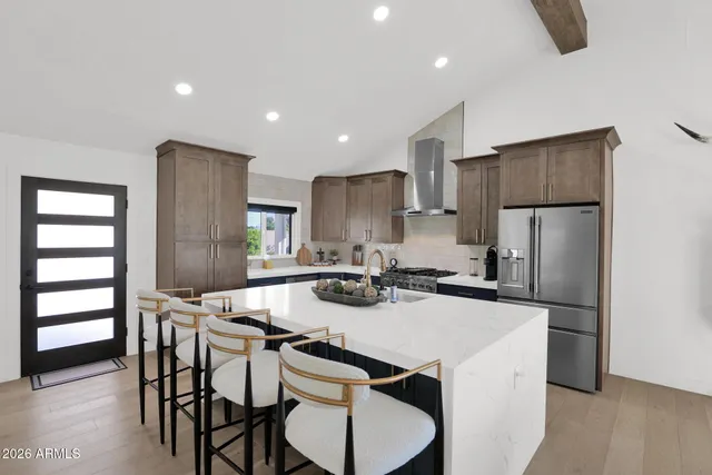 a kitchen with a dining table chairs refrigerator and microwave
