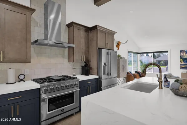 a kitchen with stainless steel appliances a stove a sink and a refrigerator