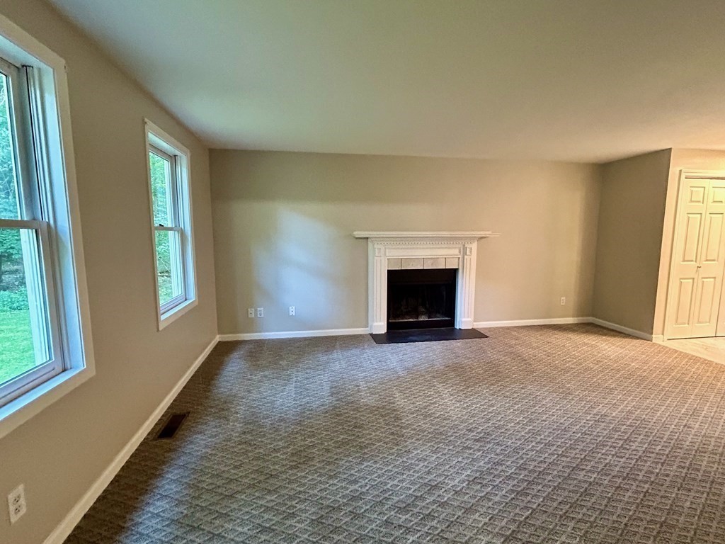 275 Burroughs Road Boxborough, MA 01719 - Photo 11 of 23 an empty room with windows and fireplace