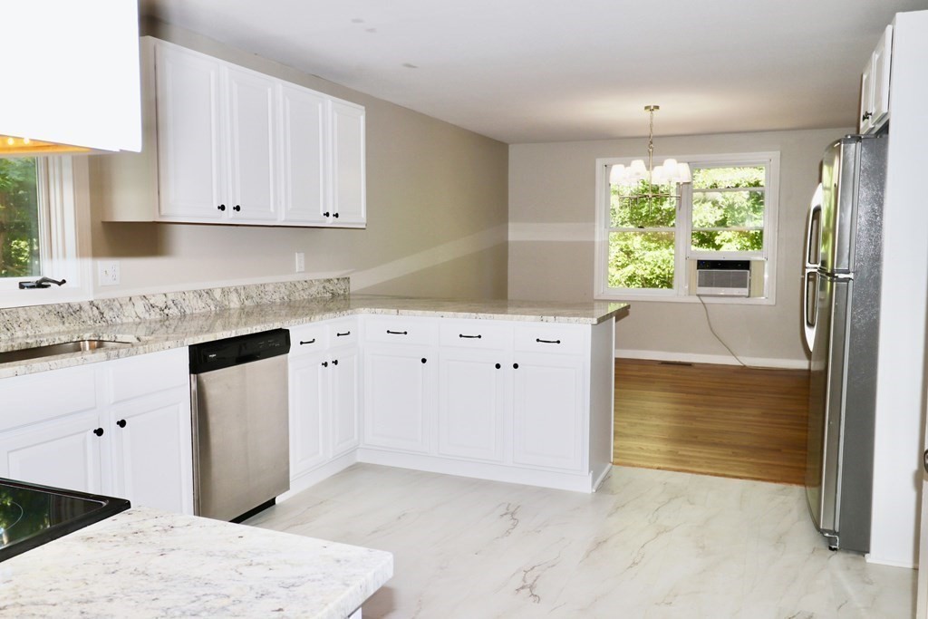 275 Burroughs Road Boxborough, MA 01719 - Photo 3 of 23 a kitchen with granite countertop white cabinets and white appliances