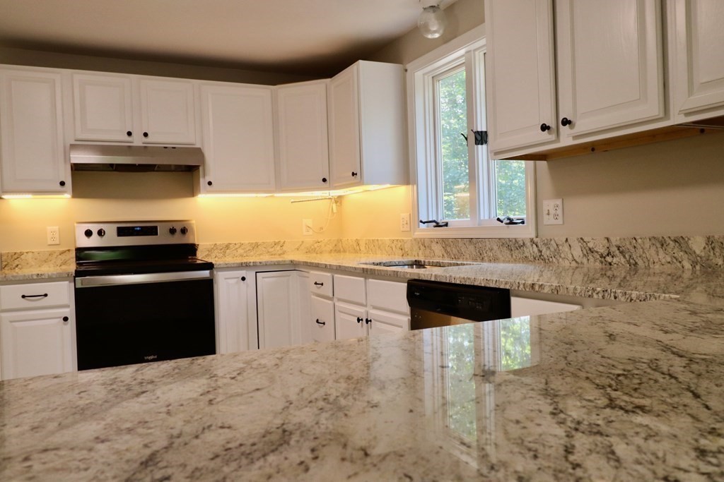 275 Burroughs Road Boxborough, MA 01719 - Photo 5 of 23 a kitchen with granite countertop a stove a sink and a microwave