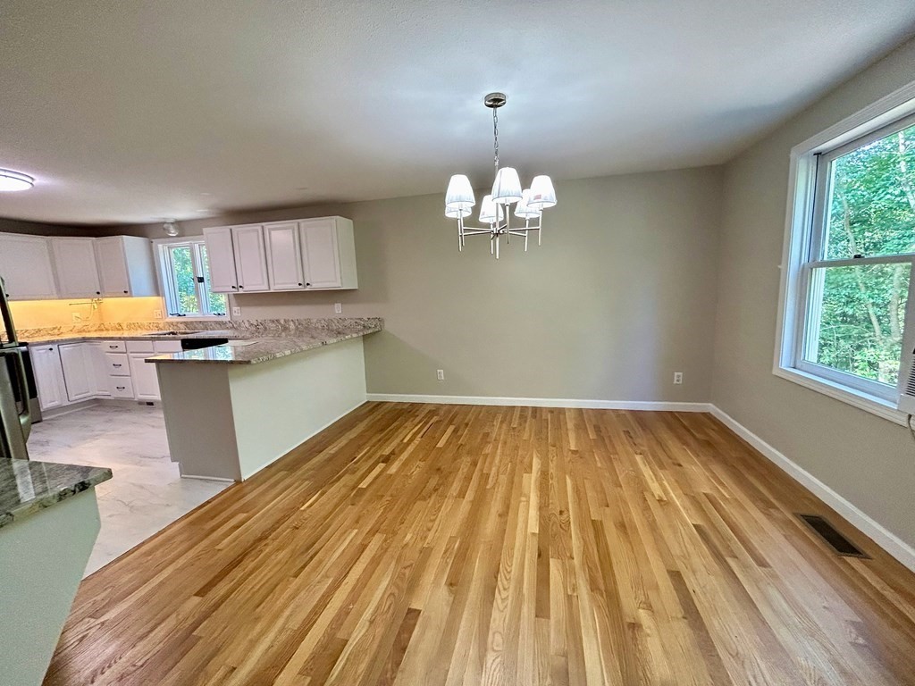 275 Burroughs Road Boxborough, MA 01719 - Photo 9 of 23 a view of a kitchen with kitchen island wooden floors stainless steel appliances a sink and a window
