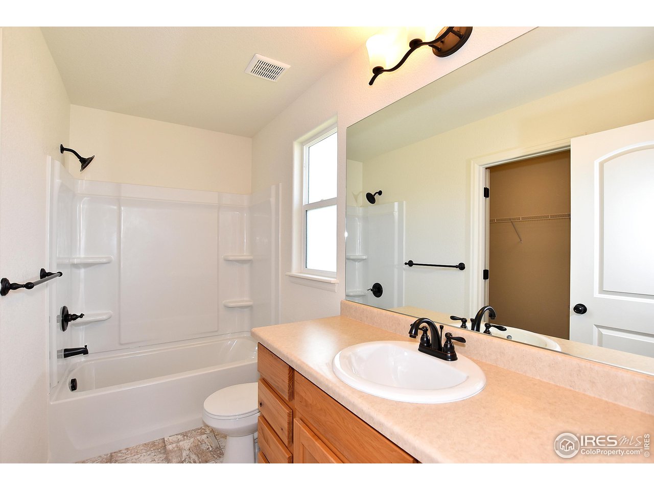 915 Milner Pass Road Severance, CO 80550 - Photo 24 of 37 a bathroom with a granite countertop sink a toilet a mirror and shower