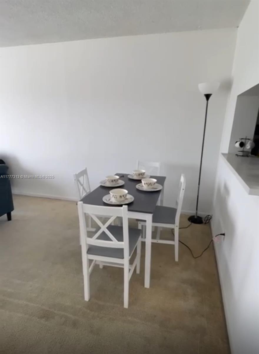 496 Northwest 165th Street, Unit D611 Miami, FL 33169 - Photo 4 of 7 a dining room with furniture and a view