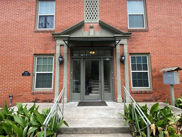 a front view of a house with a large window and potted plants