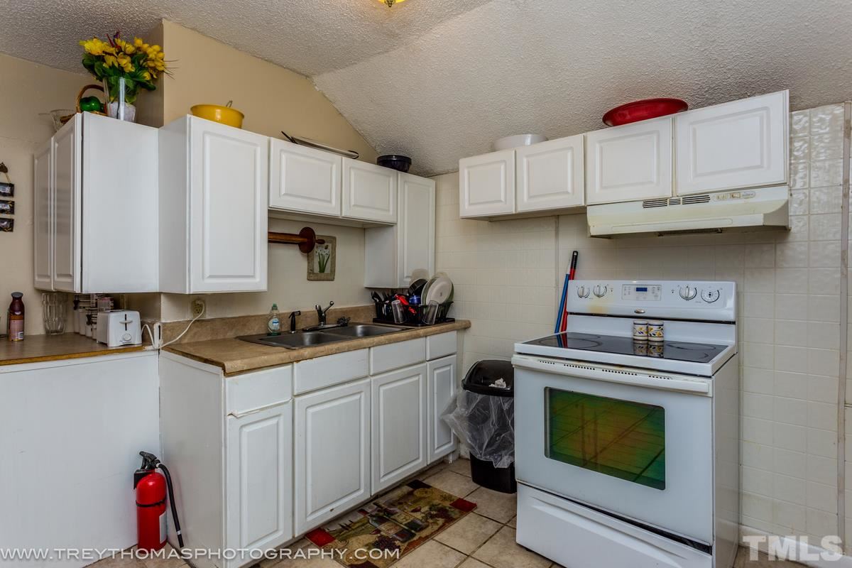 1126 Boyer Street Raleigh, NC 27610 - Photo 4 of 9 a kitchen with cabinets a stove and a sink