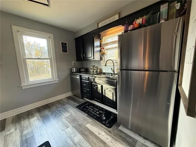 a kitchen with stainless steel appliances a refrigerator sink and cabinets