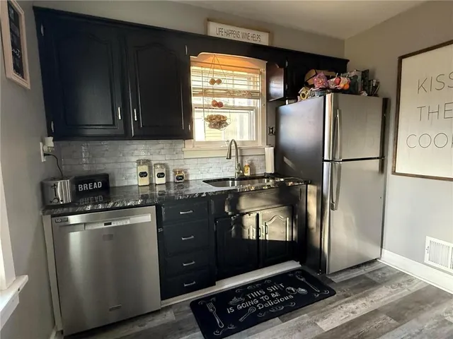 a kitchen with a refrigerator a stove a sink and a window