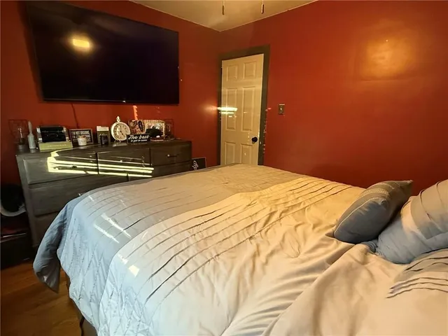a bedroom with a bed and a flat screen tv
