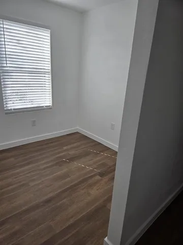 a view of a room with wooden floor and a window