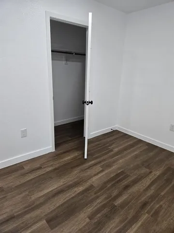an empty room with wooden floor and closet