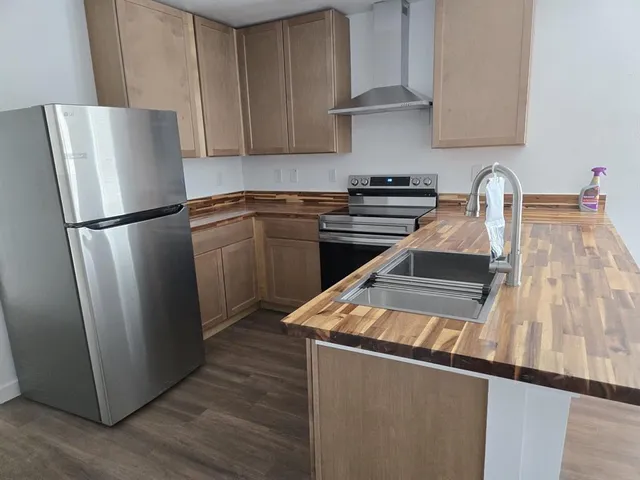 a kitchen with metallic refrigerator and a sink