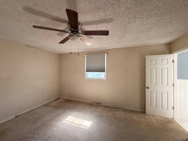 a view of a bedroom with a ceiling fan and a window