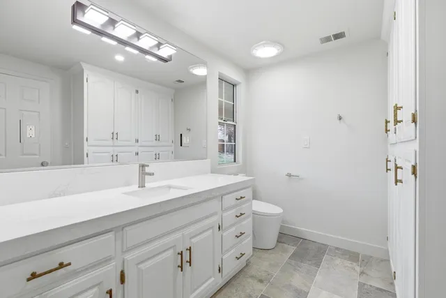 a spacious bedroom with a bed a table and chair