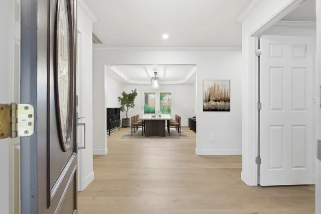 a living room with furniture a chandelier a large window and flat screen tv