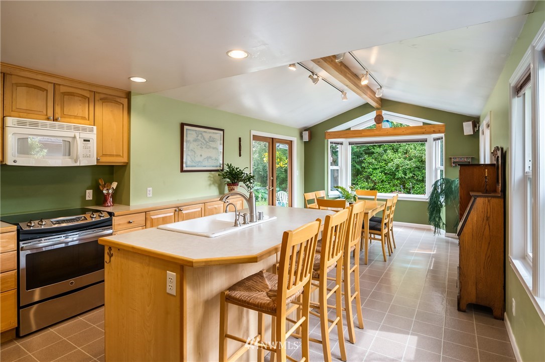 2315 North 57th Street Seattle, WA 98103 - Photo 15 of 35 a kitchen with stainless steel appliances granite countertop a stove a refrigerator a kitchen island a table and chairs in it