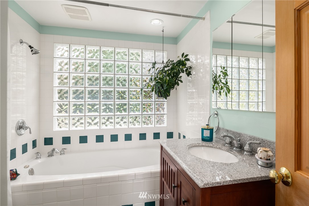 2315 North 57th Street Seattle, WA 98103 - Photo 22 of 35 a bathroom with a granite countertop tub and a sink