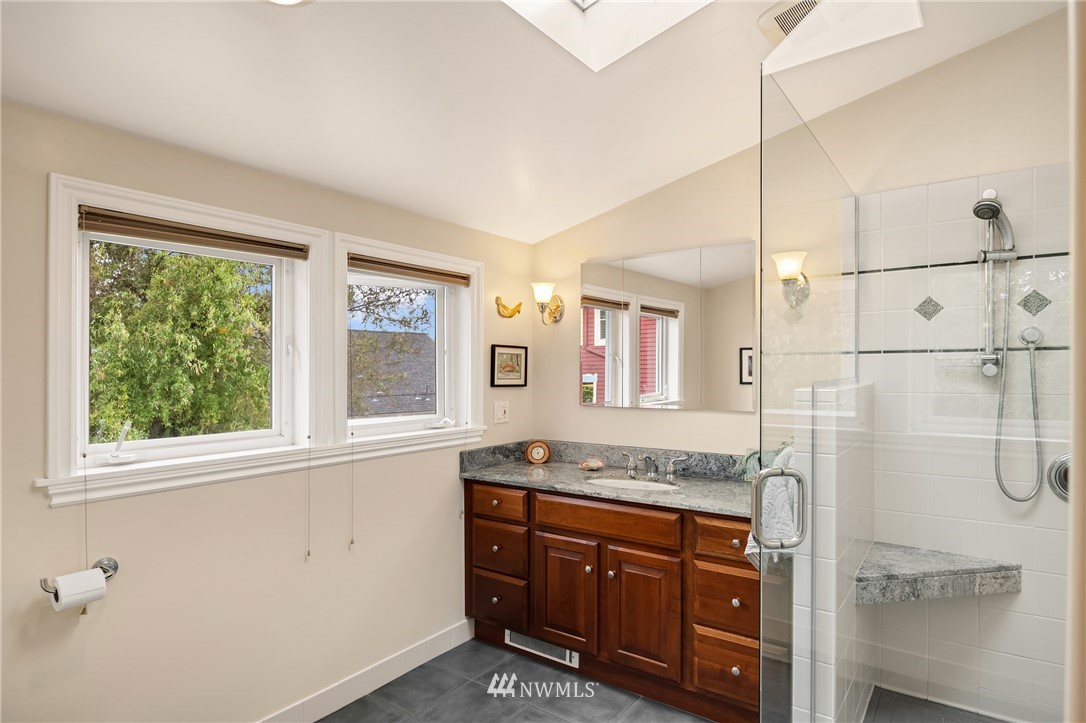 2315 North 57th Street Seattle, WA 98103 - Photo 29 of 35 a bathroom with a granite countertop sink mirror and a shower