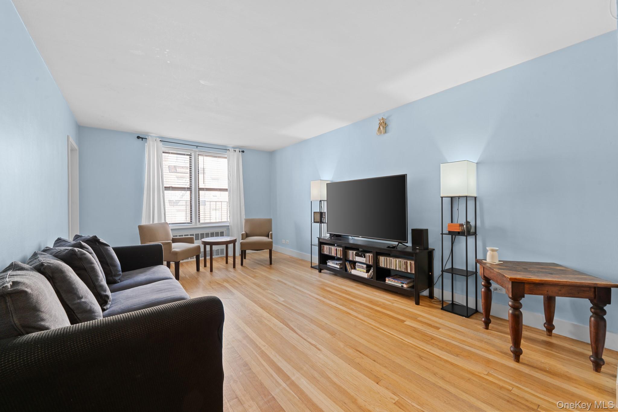 2830 Briggs Avenue, Unit 4F Bronx, NY 10458 - Photo 3 of 16 Living area featuring light wood-style flooring and radiator heating unit