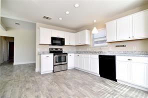 321 South Chestnut Street Forney, TX 75126 - Photo 12 of 27 a kitchen with granite countertop a refrigerator and a stove top oven