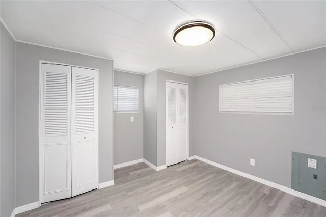 an empty room with wooden floor and window