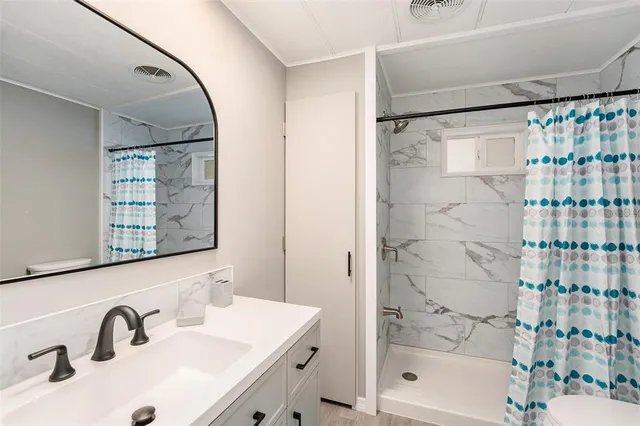 a bathroom with a sink mirror and shower