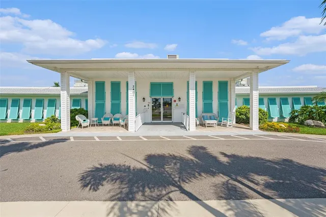 a view of a house with a yard and potted plants