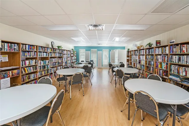 a view of living room with stainless steel appliances kitchen island granite countertop furniture and rug