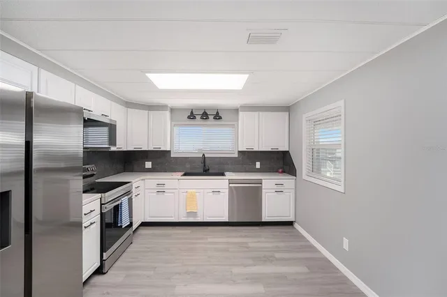 a kitchen with a stove top oven sink and cabinets