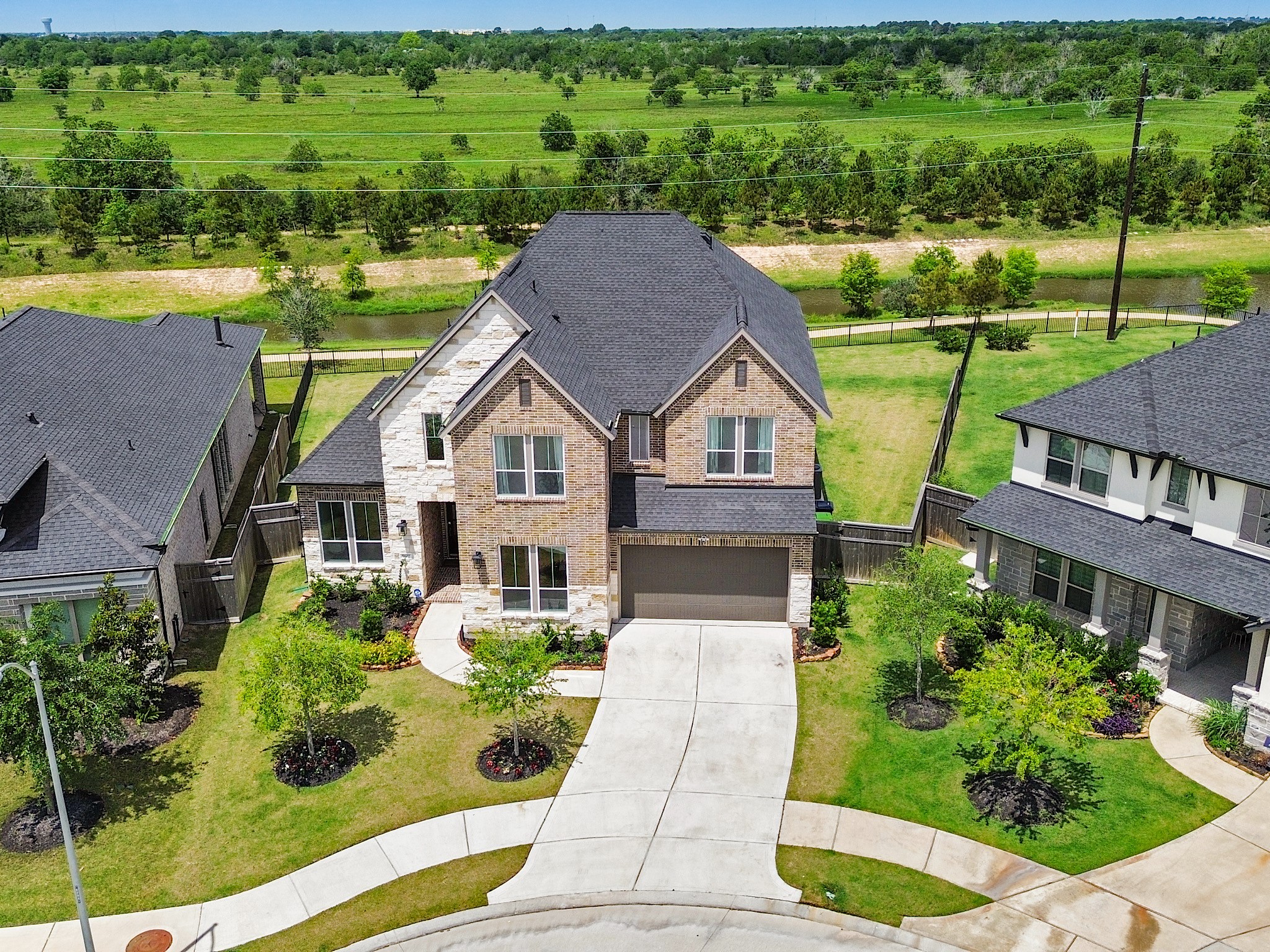 5802 Emerald Ranch Lane Fulshear, TX 77441 - Photo 2 of 45 Ideally positioned near the corner of a wide, low-traffic street, this impressive home offers exceptional curb appeal, enhanced exterior elevation details, and convenient access to nearby schools and community amenities.
